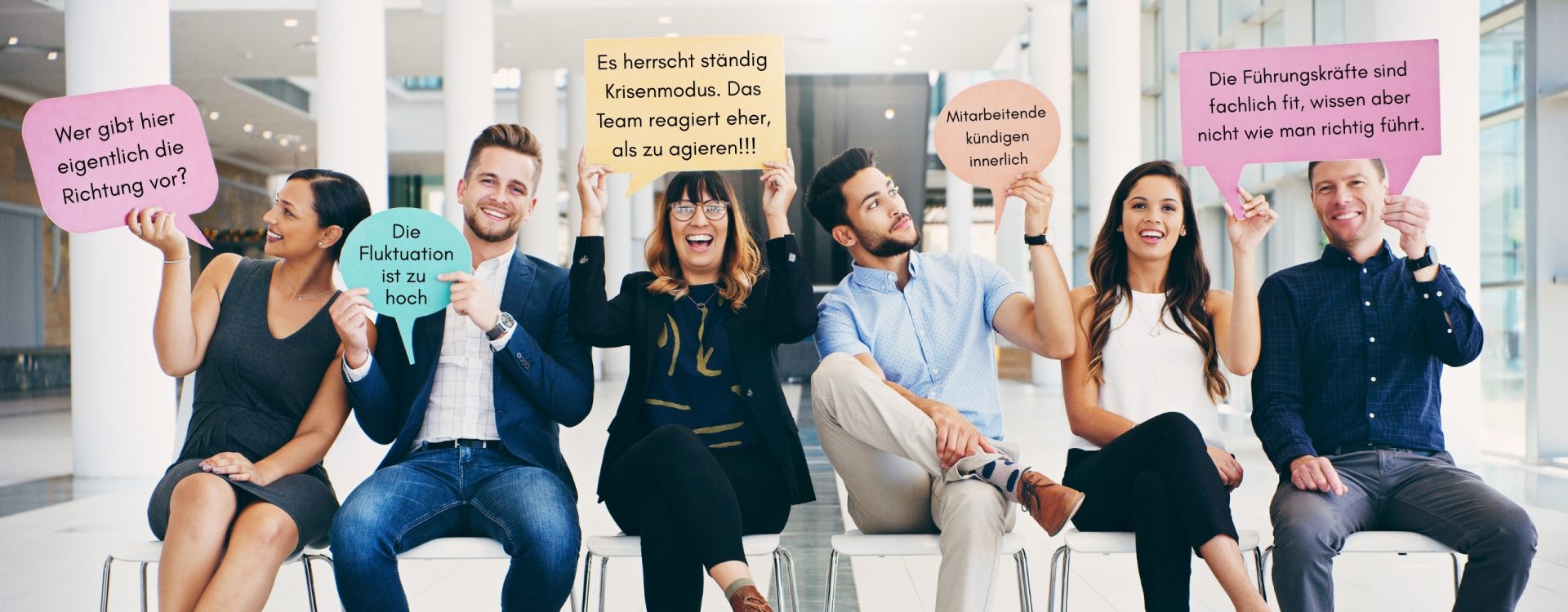 Eine Gruppe von 6 Leuten hält Schilder hoch mit Gründen für tgim.